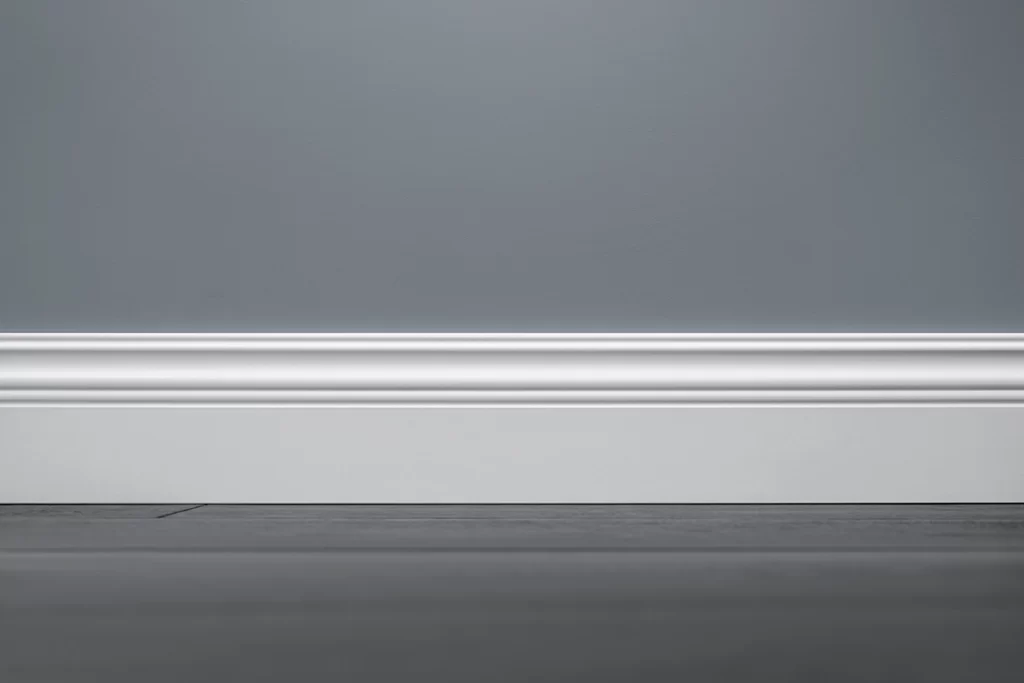 close-up-of-white-baseboard-on-blue-wall
