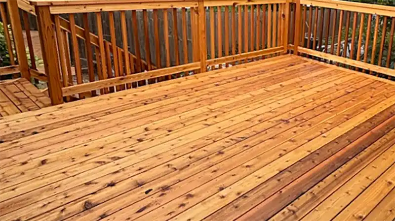Freshly built cedar deck with custom wood railing overlooking a wooded backyard