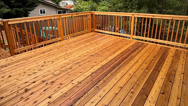 Freshly built cedar deck with custom wood railing overlooking a wooded backyard