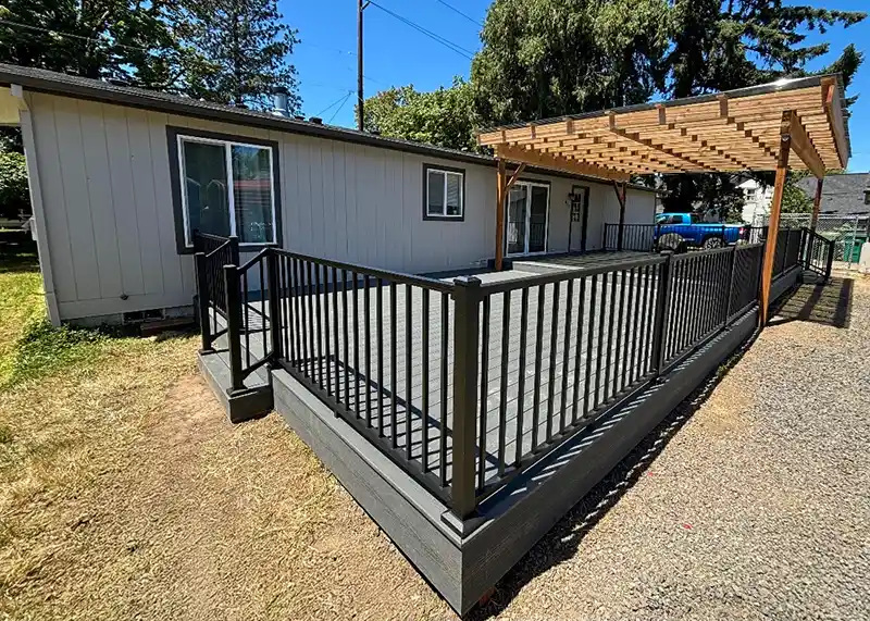 Composite deck with black metal railing and a custom wood pergola built by Salexx Construction