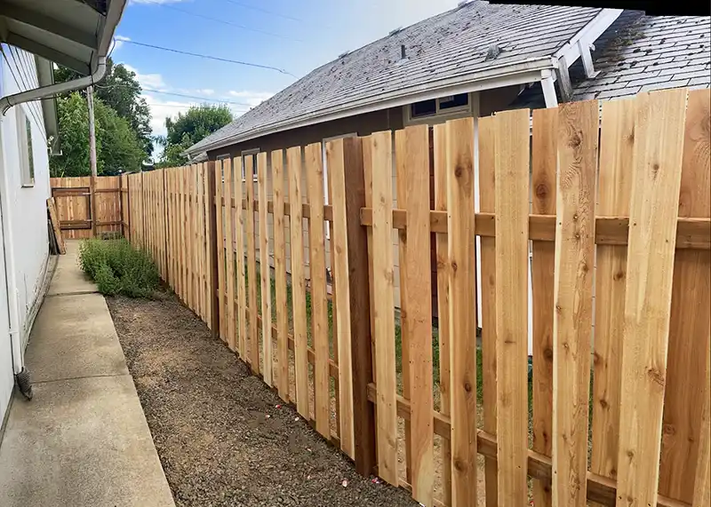 New cedar fence installation along a residential side yard