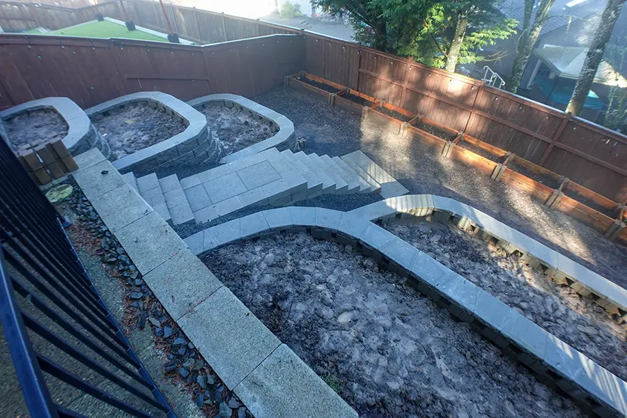 Backyard retaining walls and raised planter beds prepared for outdoor living landscape design in Newberg, Oregon