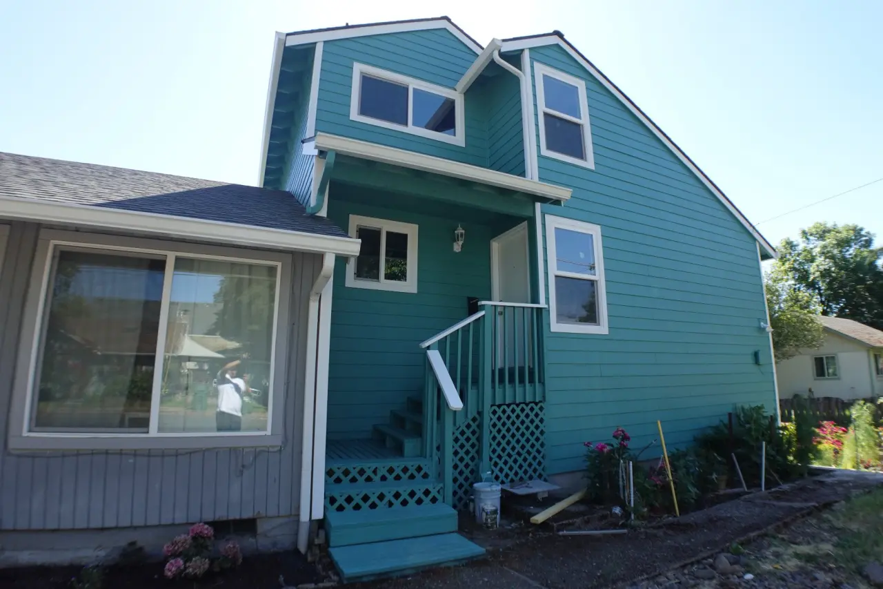 Two-story home repainted in teal